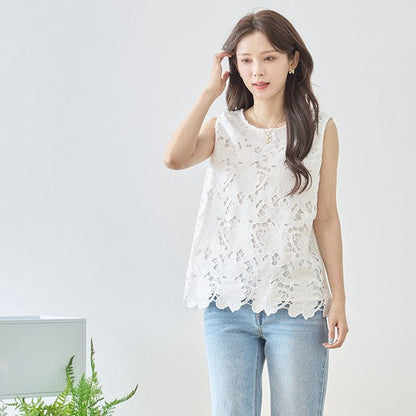 Mikonosublue Storeの白いフラワーカットワークレースのノースリーブトップス。裾はスカラップ仕様で、ゆったりとしたシルエットが特徴。