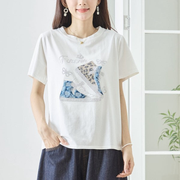 Mikonosublue Storeのラインストーンと異素材パッチワークのスニーカー柄が施されたホワイトの半袖コットンTシャツ
