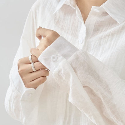 Mikonosublue Store white sheer long-sleeve blouse with floral lace details and button-up front.