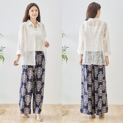Mikonosublue Store white sheer long-sleeve blouse with floral lace paneling and a relaxed fit, worn by a model with patterned navy pants.