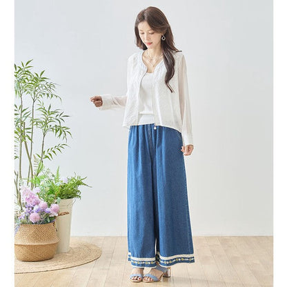 Mikonosublue Storeのホワイトのシアーレースジャケット。フラワーカットワークとパールボタンが特徴のバックロング丈ライトアウター。