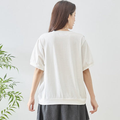 Mikonosublue Storeのホワイトの半袖Tシャツ。背面は無地でゆったりとしたシルエット、袖口にギャザーを寄せた綿混素材のトップス。
