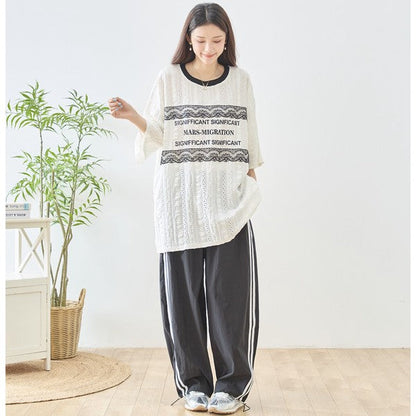 Mikonosublue Storeの胸元にレースとロゴをあしらったアイボリーの透かし編みビッグシルエット半袖トップス